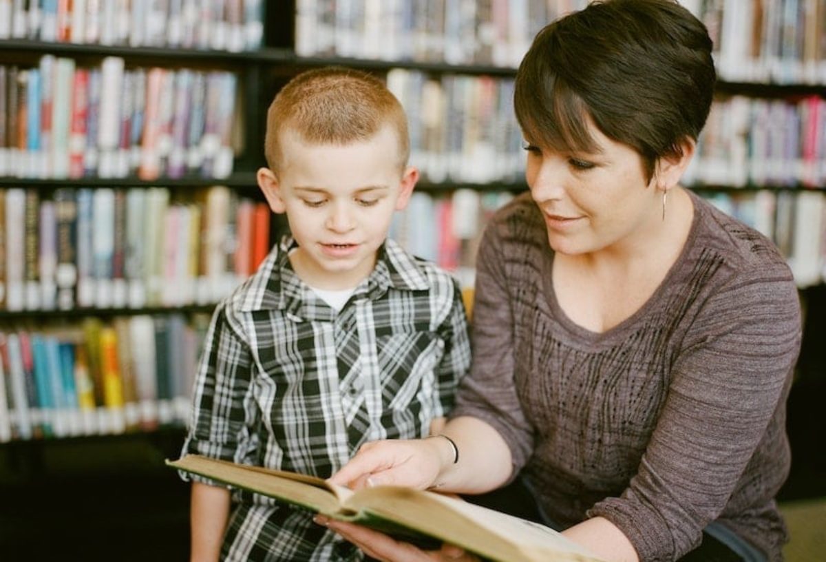 Woman showing book to child