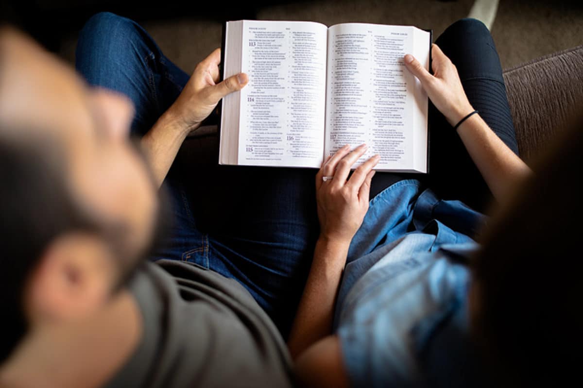 A couple reading Bible together as they pass on faith in their family