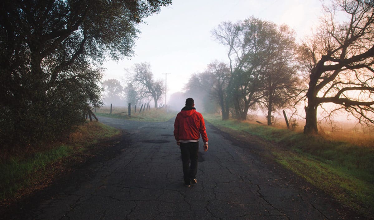 Man walks alone down a quiet road