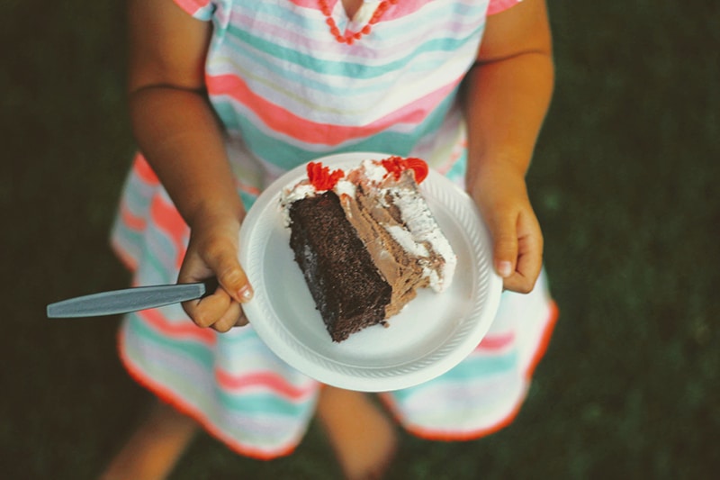 Woman holding slice of chocolate cake