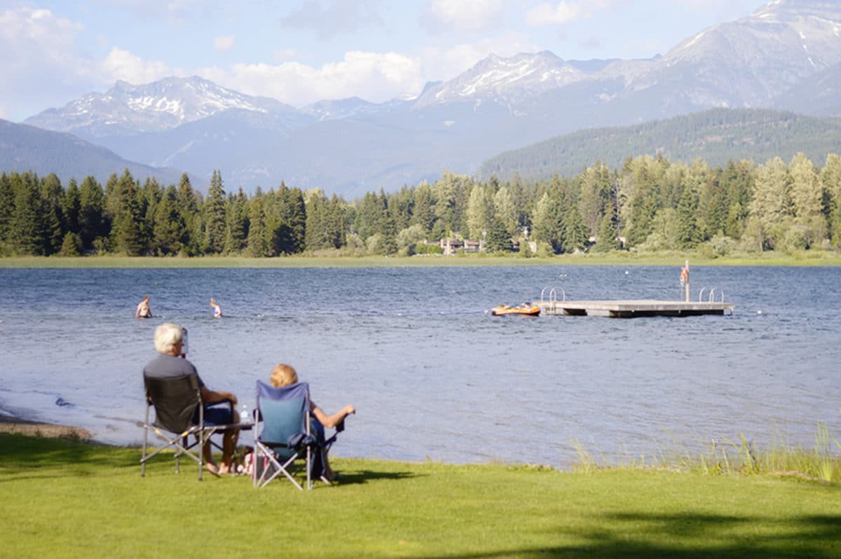 A couple in Canada sits next to the lake during retirement