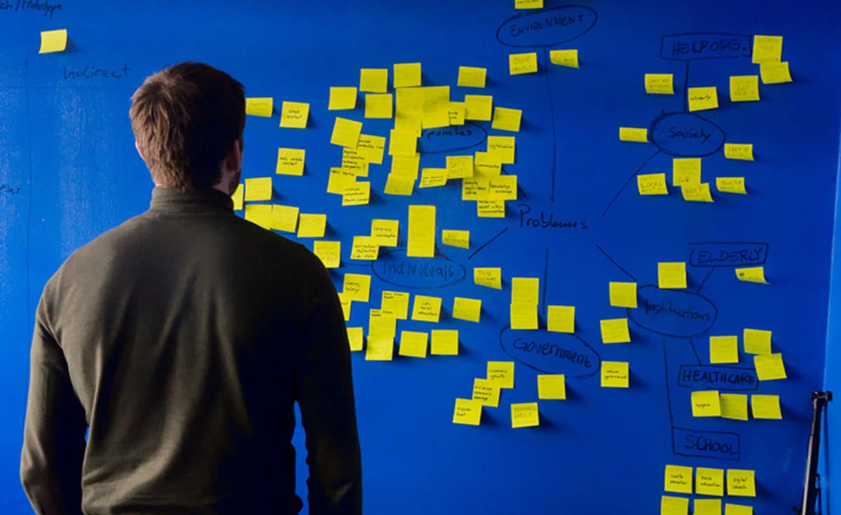 Man looks at wall of planning notes