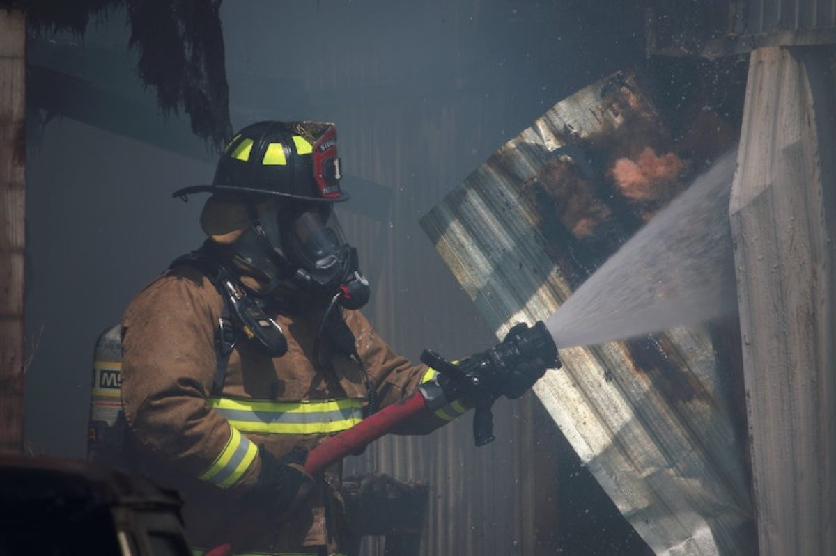 Firefighter spraying water into building